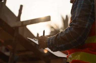 Construction worker writing on clipboard