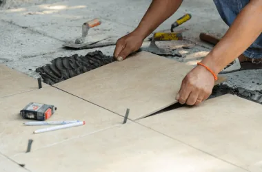 Applying grout between light gray tiles