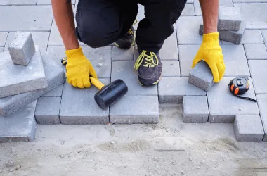 Placing concrete paver on sand bed